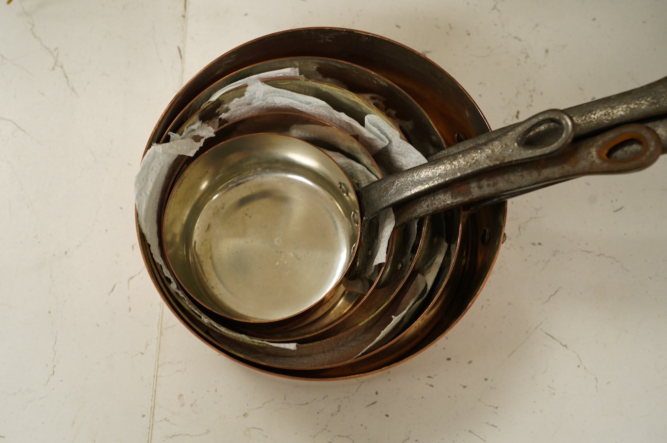 A set of five graduated copper pans, largest diameter 18cm. Condition - fair